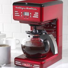 Nostalgia Retro 12-Cup Coffee Maker in pink with a retro design, featuring a programmable timer and anti-drip function. 