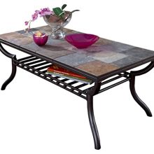 A stylish coffee table with a mosaic slate tile top and a grilled lower shelf, set against a cozy living room backdrop. 