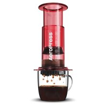 Clear red AeroPress coffee maker on a kitchen counter, offering 3-in-1 brewing options, perfect for travel, camping, and daily use